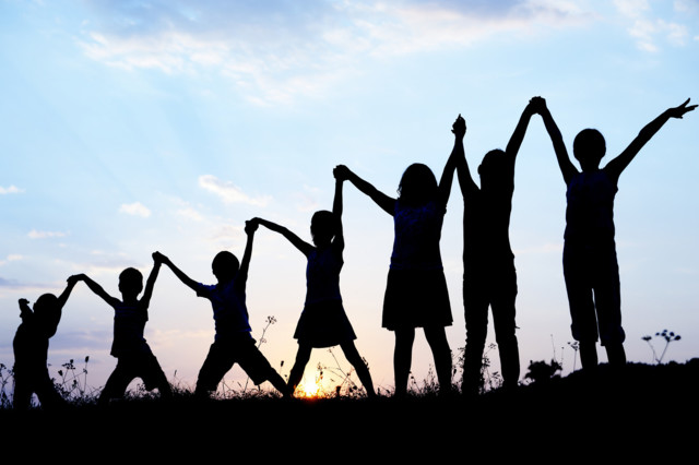 children_silhouettes_holding_hands_up_by